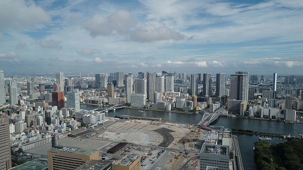 更地になった築地市場跡地の空撮。広大な空き地の向こう、隅田川をはさんで勝どきのタワーマンション群が並ぶ